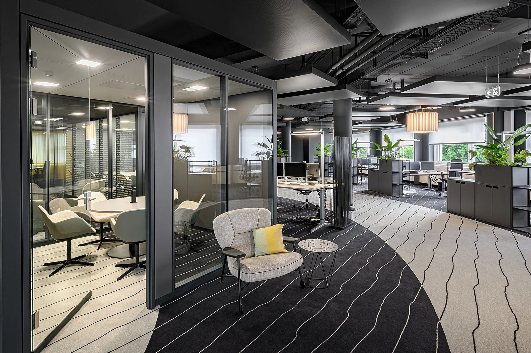 A view of the freestanding GK SPACES room solution, utilized as a meeting room. Inside, there is a meeting table with six chairs. The all-glass door is half-open.